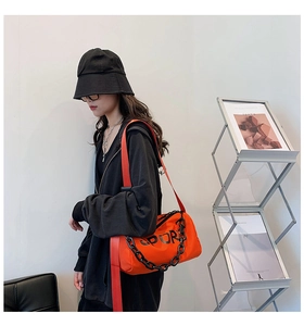 Détail du sac bandoulière en nylon orange vif avec chaîne noire et lettrage Sport
