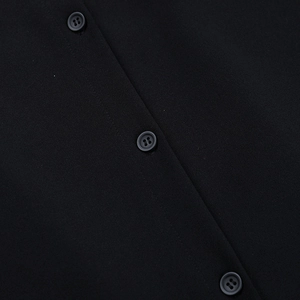 Gros plan d'une robe chemise noire avec tissu texturé et trois boutons assortis
