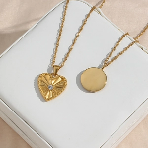 Dettaglio del ciondolo a cuore placcato oro 18K con trama a raggiera e zircone su seta
