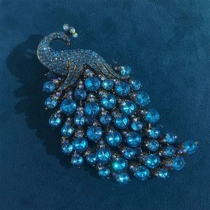 Detail of vintage peacock brooch with blue crystals and rhinestones on bronze alloy base