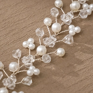 Macro detail of bridal hairband with handmade ceramic flowers, pearls and crystals