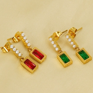 Detailed macro of vintage rectangular earrings with emerald green stones and white pearls