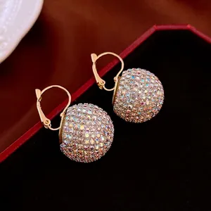 Sparkling gold ball hook earrings with rainbow pavé crystals on red jewelry box