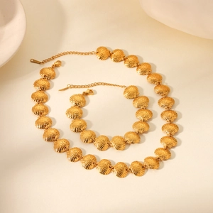 Detail of 18K gold stainless steel shell necklace and bracelet set with metallic luster