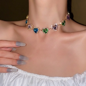 Colorful heart-shaped crystal choker necklace with gold setting on model neck
