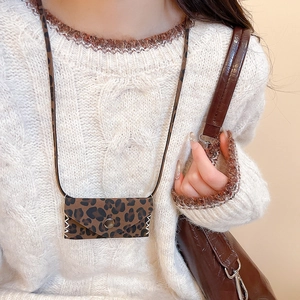 Detail of leopard print mini crossbody bag necklace with visible white stitching