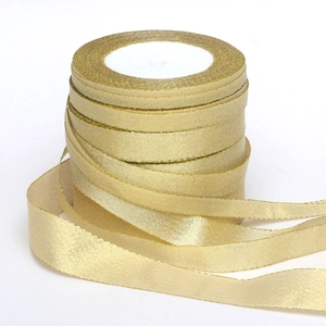 Detail shot of a roll of sparkling metallic gold glitter ribbon for festive decoration