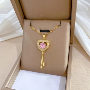 Titanium steel heart key necklace with pink gemstone and crystals in a beige jewelry box