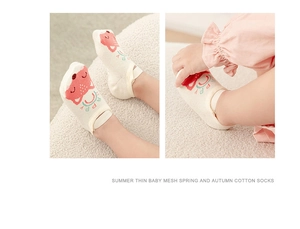 Detail of white mesh baby socks featuring cute cartoon fox patterns and tie straps