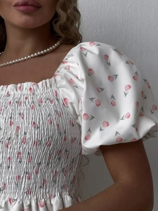 Detail of smocked bodice and puff sleeves on a floral tulip print summer dress
