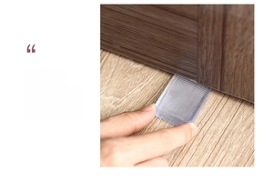 Transparent wedge door stopper with anti-slip ridges being inserted under a wooden door