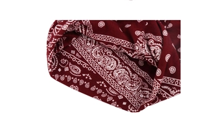 Detail view of burgundy paisley cotton beanie showing fabric texture and inner lining