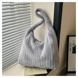 Detail showing plush light gray faux fur texture and vertical stripes on a chic tote bag