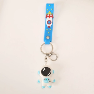Porte-clés astronaute en silicone et fusée bleue avec clip en métal sur fond blanc