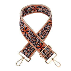 Detail of ethnic embroidered strap with golden hardware and adjustable metal buckle