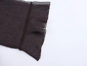 Detailed close-up of dark brown translucent chiffon fabric texture and stitching edges