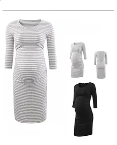 Detail of ruched side maternity dress featuring elastic fabric and slimming crew neck design