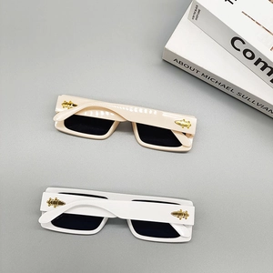 Detail of square off-white sunglasses with metallic insect logo on the temple