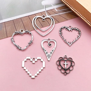 Detailed view of silver alloy heart pendants in gothic and filigree styles for DIY jewelry