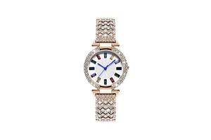 Détail d'une montre de luxe en or rose avec lunette en strass et index en pierres colorées