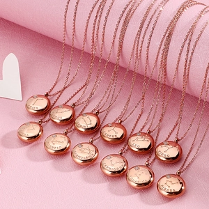 Rose gold zodiac sign necklaces with round constellation pendants on pink background