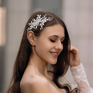 Gros plan d'une pince à cheveux de mariée argentée avec perles blanches et cristaux