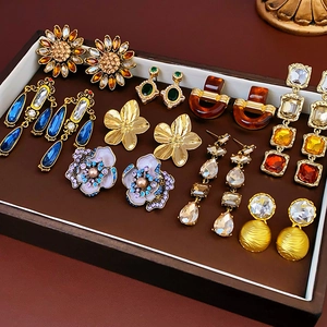 Collezione di orecchini vintage a fiore e perni di cristallo in un vassoio per gioielli