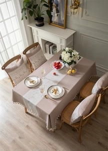 Detail of beige jacquard tablecloth featuring reindeer patterns and delicate fringe tassels