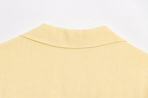 Macro view of light yellow linen shirt collar showing detailed fabric fiber texture