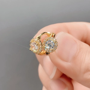 Macro detail of gold plated hoop earrings with micro-paved cubic zirconia round halo design