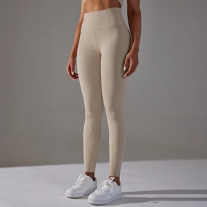 Detail of high-waist yoga leggings with beige honeycomb knit texture and elastic fabric