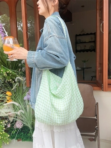 Sac cabas en toile à carreaux vert clair porté à l'épaule par un mannequin en extérieur