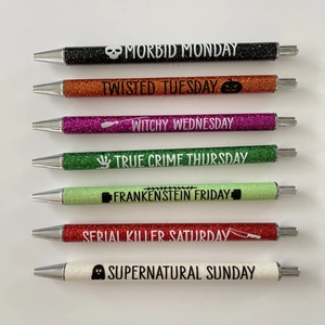 Set of 7 multi-color Halloween glitter pens with daily themes on white background