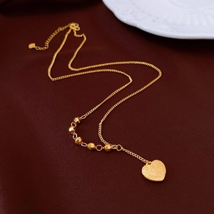 Dettaglio della collana a cuore placcata oro 18K con texture spazzolata su velluto