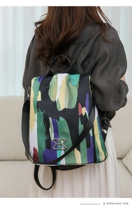 Detailed back view of a colorful abstract pattern anti-theft backpack on a model