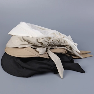 Detail view of cotton sun hats in white, beige, khaki and black with bow ribbons