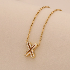 Detail of gold cross pendant necklace with sparkling inlaid stones on O-chain