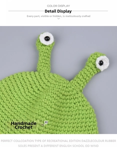 Close-up of handmade green knit frog hat with detailed crochet eyes and texture