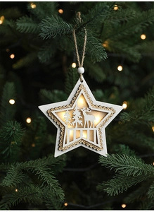 Close-up of glowing wooden star ornament with reindeer laser cutouts on a Christmas tree