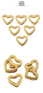 Detailed view of hollow heart-shaped gold pendants with engraved vintage textures