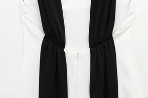 Detail of invisible back zipper and contrast stitching on black and white mini dress