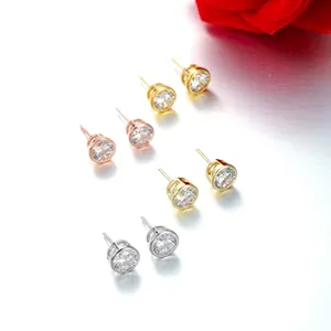 Close-up of four pairs of cubic zirconia stud earrings in gold and silver finishes