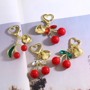 Lot de quatre porte-clés cerises rouges avec fermoir cœur et détails de feuilles en cristal