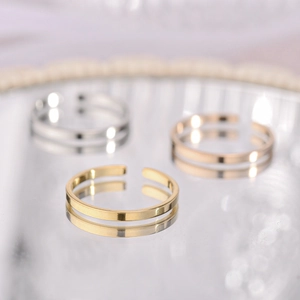 Detailed macro view of minimalist open rings in gold, silver, and rose gold finishes