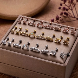 Macro shot of 24 stainless steel studs with butterfly, moon and crown zircon designs
