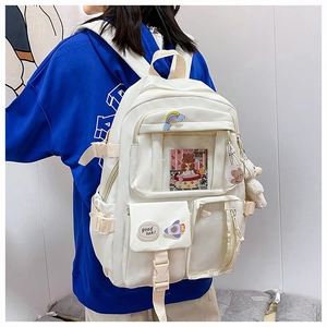 Detail of off-white nylon backpack with functional pockets, cute badges and plush lamb pendant