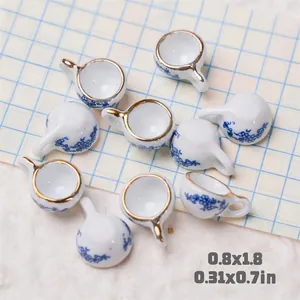 Detailed macro view of 10 mini ceramic teacups with blue floral pattern and gold rim