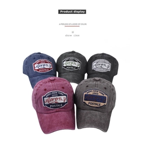 Detailed close-up showing five colors of washed cotton baseball caps with vintage embroidery