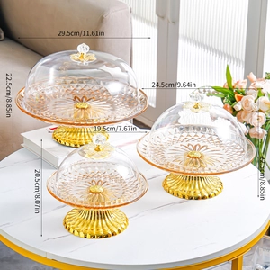 Three-tier glass cake stands with gold bases and domed covers in various sizes