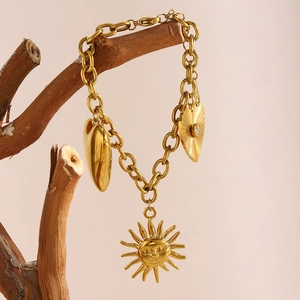 18K gold plated stainless steel chain bracelet with sun and heart charms on wood